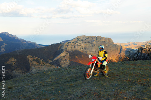 Fototapeta Naklejka Na Ścianę i Meble -  Man in sport equipment riding a motorcross bike in mountains