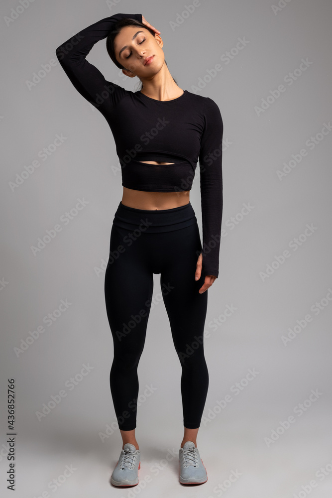 Female stretching before training on grey background Female stretching before training on grey background