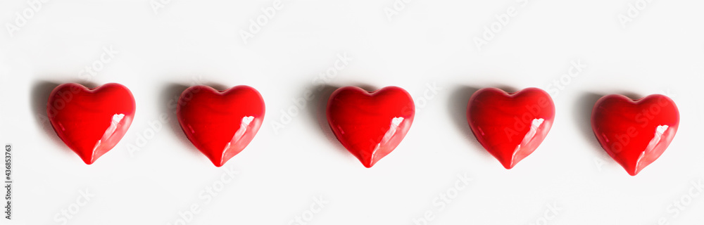 Five red hearts isolated on white background. Panorama