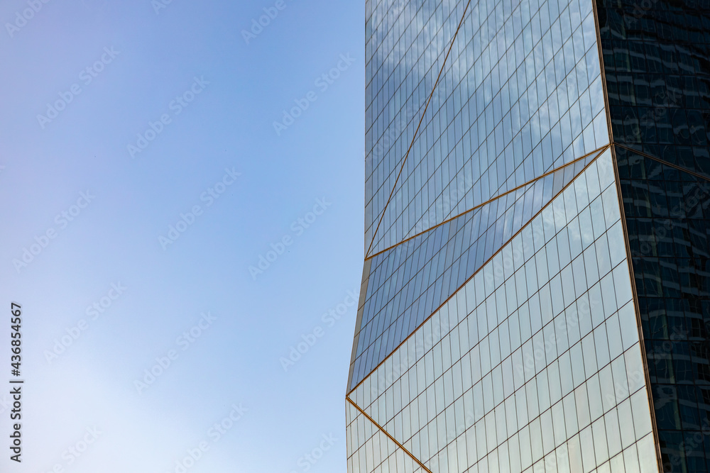 Glass skyscraper against blue sky, view from bottom Glass skyscraper against blue sky, view from bottom