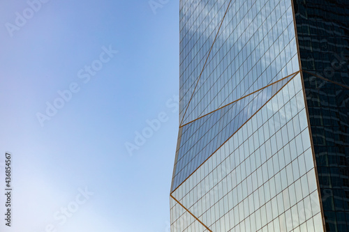 Glass skyscraper against blue sky, view from bottom