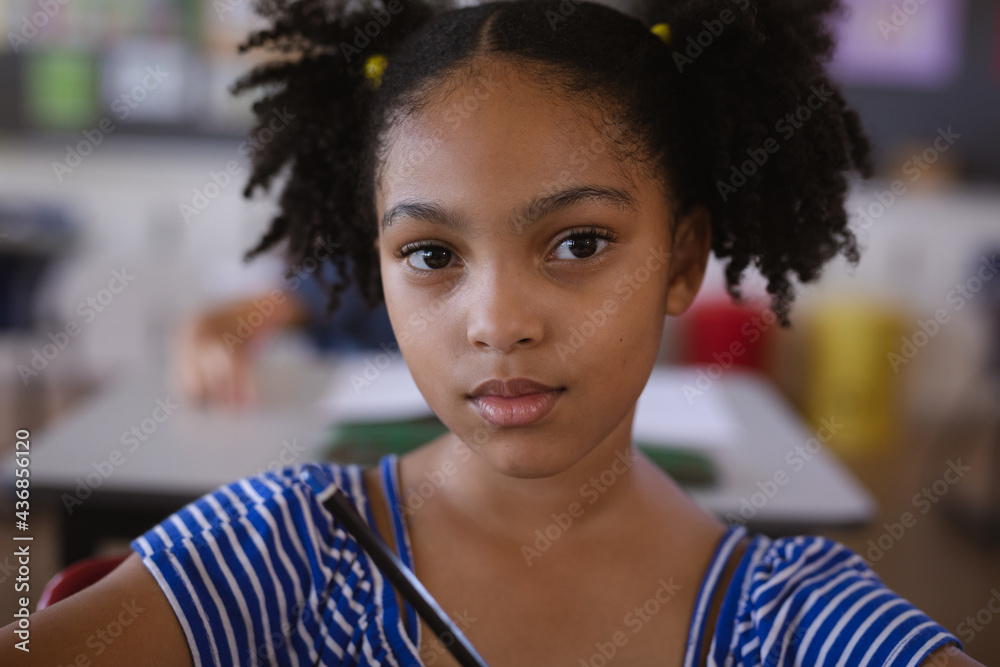 Portrait of african american girl sitting on her desk in the class at ...