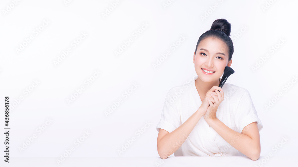 Glamour young woman smile and holding make-u brush with healthy clean and fresh skin while looking at camera over isolated white background. Beauty and cosmetics concept. Glamour young woman smile and holding make-u brush with healthy clean and fresh skin while looking at camera over isolated white background. Beauty and cosmetics concept.