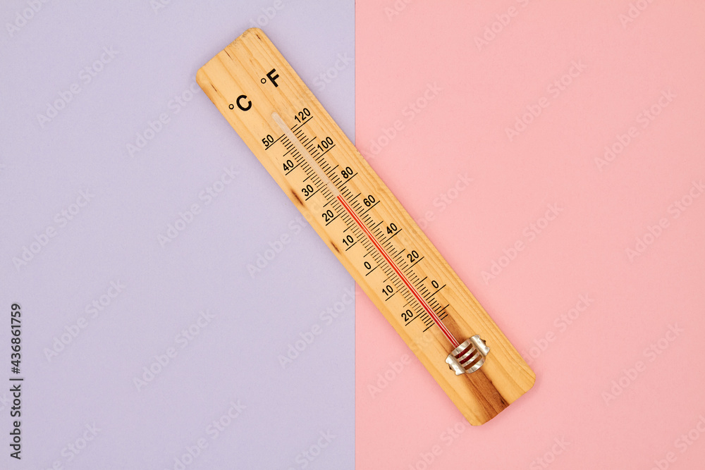 Close-up photo of wooden household alcohol thermometer showing temperature in degrees Celsius on a colorful background. Close-up photo of wooden household alcohol thermometer showing temperature in degrees Celsius on a colorful background.