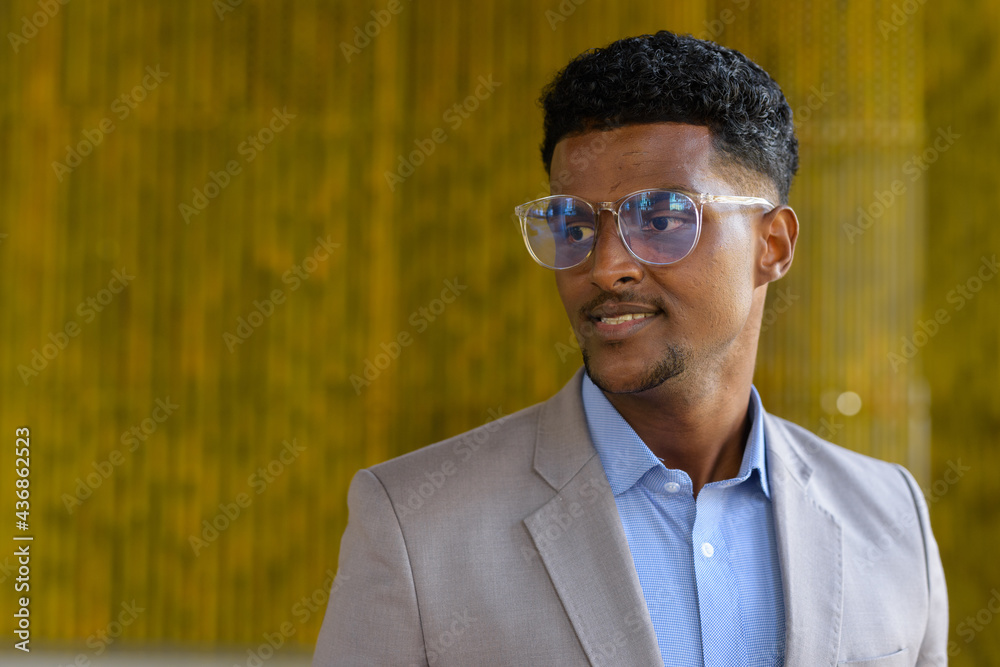 Portrait of stylish young African businessman outdoors wearing eyeglasses and smiling Portrait of stylish young African businessman outdoors wearing eyeglasses and smiling