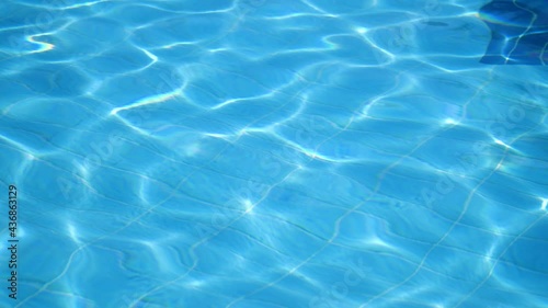 Pure shining and calming light blue waters Impressive background from rippling, surging up and down in a swimming pool outdoors in summer