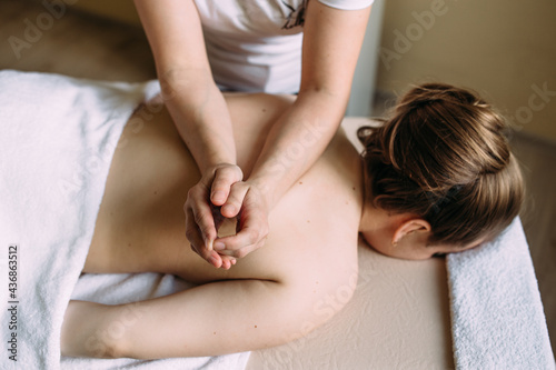 Massage therapist doing massage on the female body in the spa. © Zhuravleva Katia