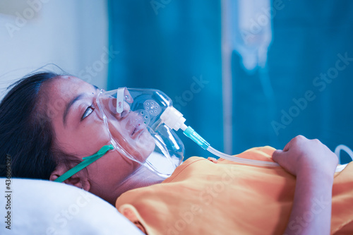 Fotografia side view of girl kid breathing on ventilator oxygen mask due to coronavirus covid-19 breathing shotness or dyspnea - concept of children Healthcare and medical during third wave pandemic outbreak