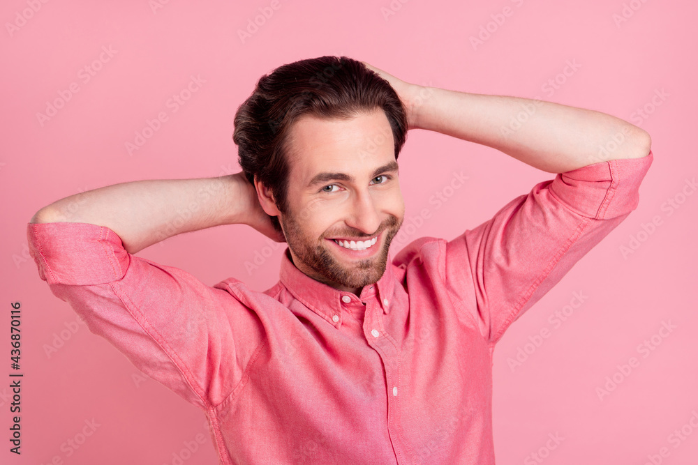 Photo of attractive young cool charming man hold hands hair barber shop isolated on pastel pink color background Photo of attractive young cool charming man hold hands hair barber shop isolated on pastel pink color background