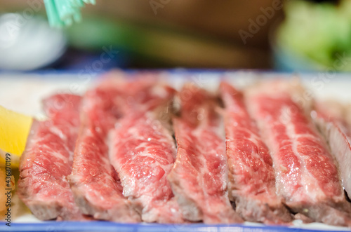 Sliced grilled Strip Loin rare degree of ripeness beef steak served with salt.