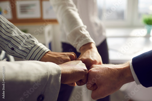 Teamwork and teambuilding, partnership collaboration. Closeup business team bumping fist jointing hand together standing in office. Colleague assembly and corporate union or reunion motivation photo