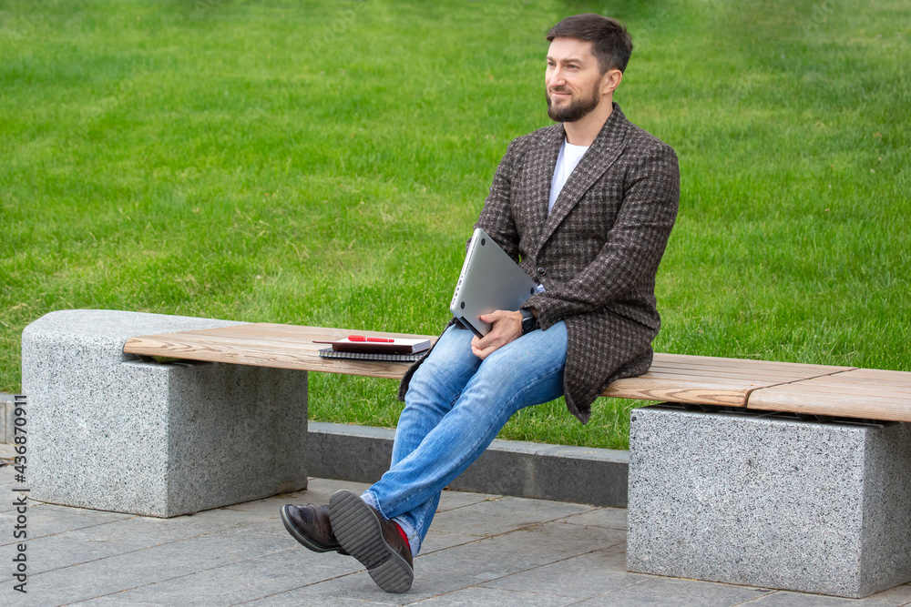 successful businessman resting on a city bench after a completed work project