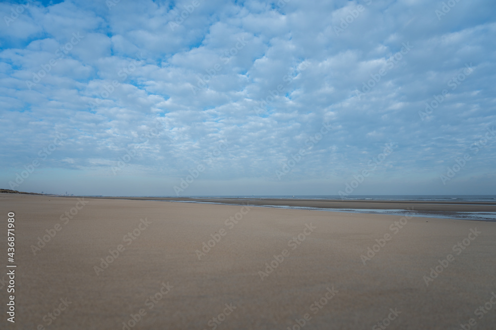 Low tide period on yellow sandy beach in small Belgian town De Haan or Le Coq sur mer, luxury vacation destination, summer holidays Low tide period on yellow sandy beach in small Belgian town De Haan or Le Coq sur mer, luxury vacation destination, summer holidays