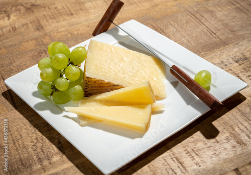 Cheese collection, piece of spanisch hard manchego cheese made in La Mancha region from sheep milk with green grapes photo