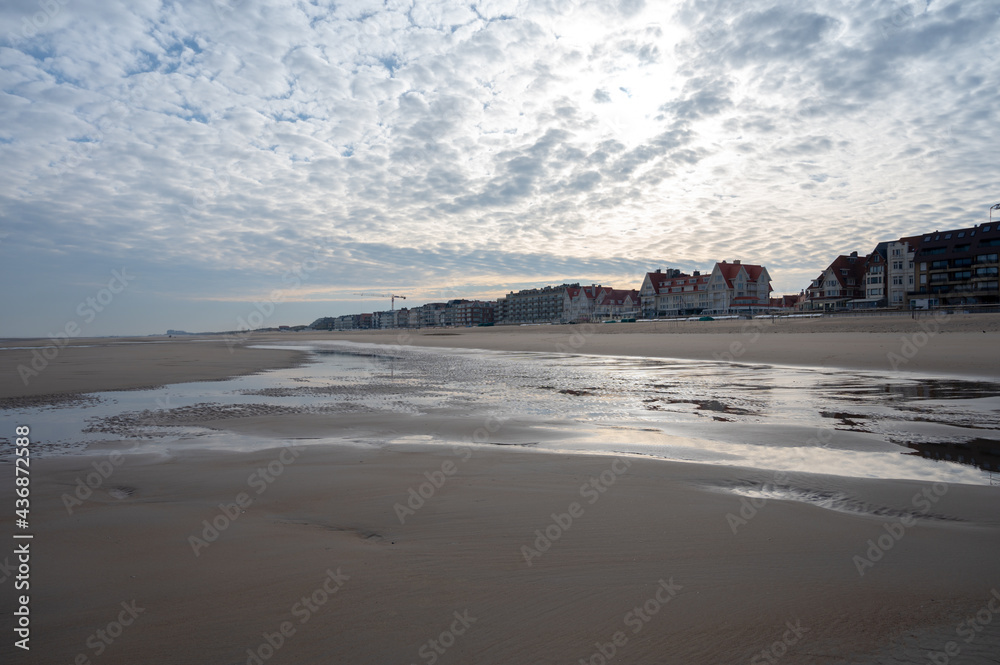 Fototapeta premium Low tide period on yellow sandy beach in small Belgian town De Haan or Le Coq sur mer, luxury vacation destination, summer holidays