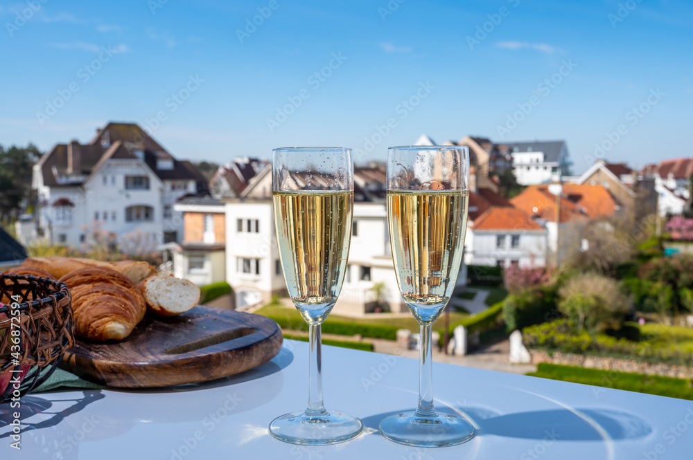 Fototapeta premium Drinking of brut champagne sparkling wine in flute glasses on outdoor bistro terrace in France
