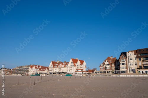 Yellow sandy beach in small Belgian town De Haan or Le Coq sur mer, luxury vacation destination, summer holidays © barmalini