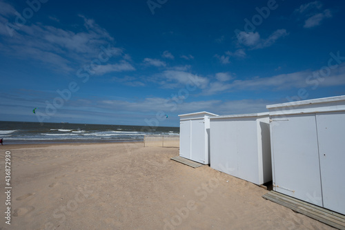 White beach huts on yellow sandy beach in small Belgian town Knokke-Heist, luxury vacation destination, summer holidays © barmalini