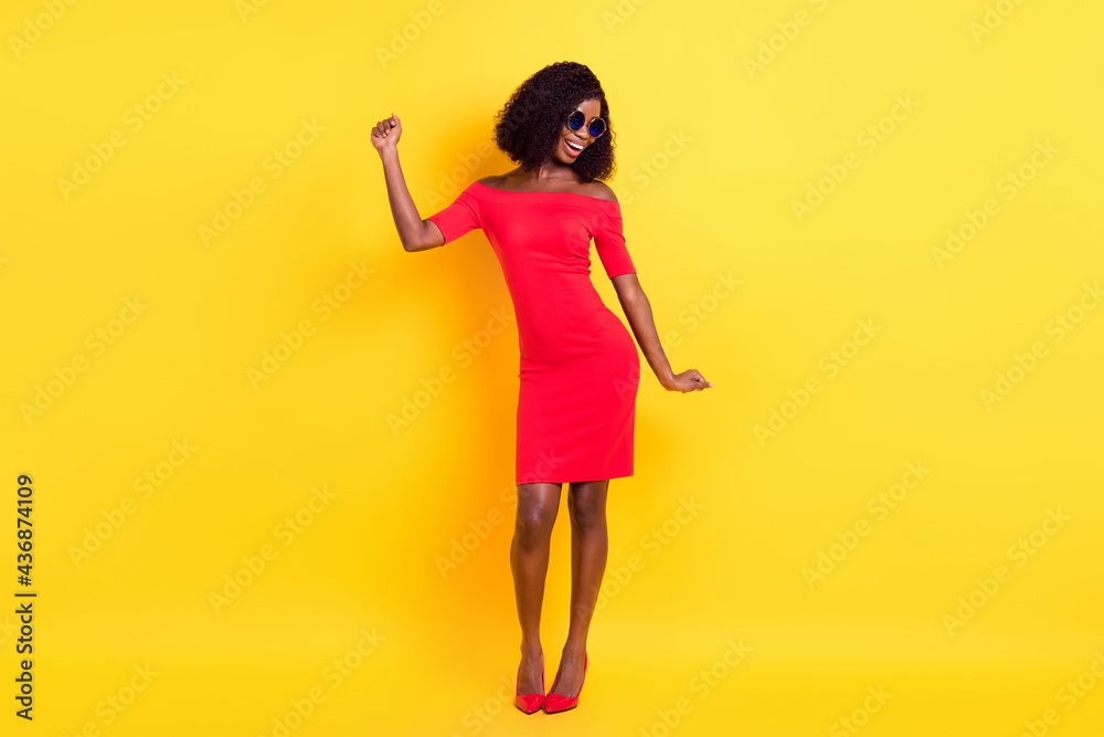 Full length photo of adorable charming dark skin woman wear red clothes eyewear dancing isolated yellow color background Full length photo of adorable charming dark skin woman wear red clothes eyewear dancing isolated yellow color background