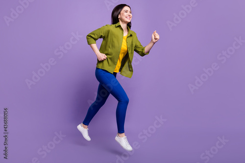 Full body profile side photo of young girl happy positive smile jump run speed hurry sale isolated over violet color background © deagreez