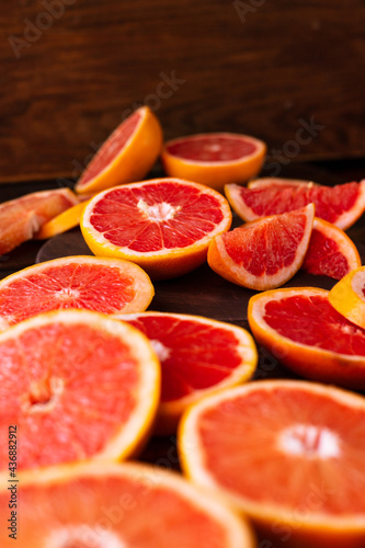 sliced pieces of grapefruit lie on the table on the dark wooden countertop