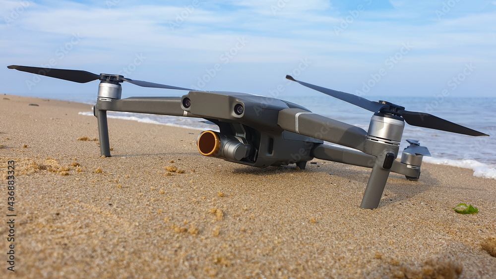Closeup of a modern drone on a beach. Closeup of a modern drone on a beach.
