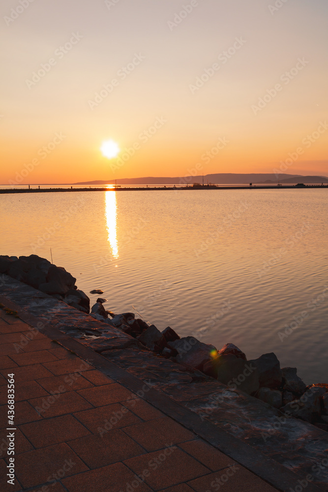 Obraz premium Beautiful panorama of Lake Balaton near the town of Fonyod, in the background the Badacsony Mountains and Szigliget at sunset