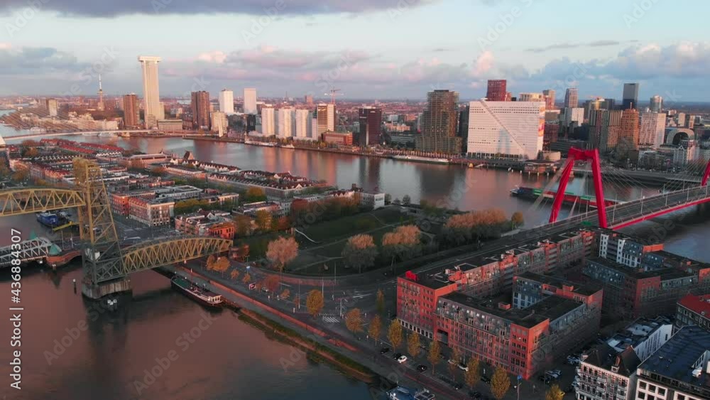 Beautiful drone video of the skyline of Rotterdam during sunrise. Bridges connecting the different sides of the city.