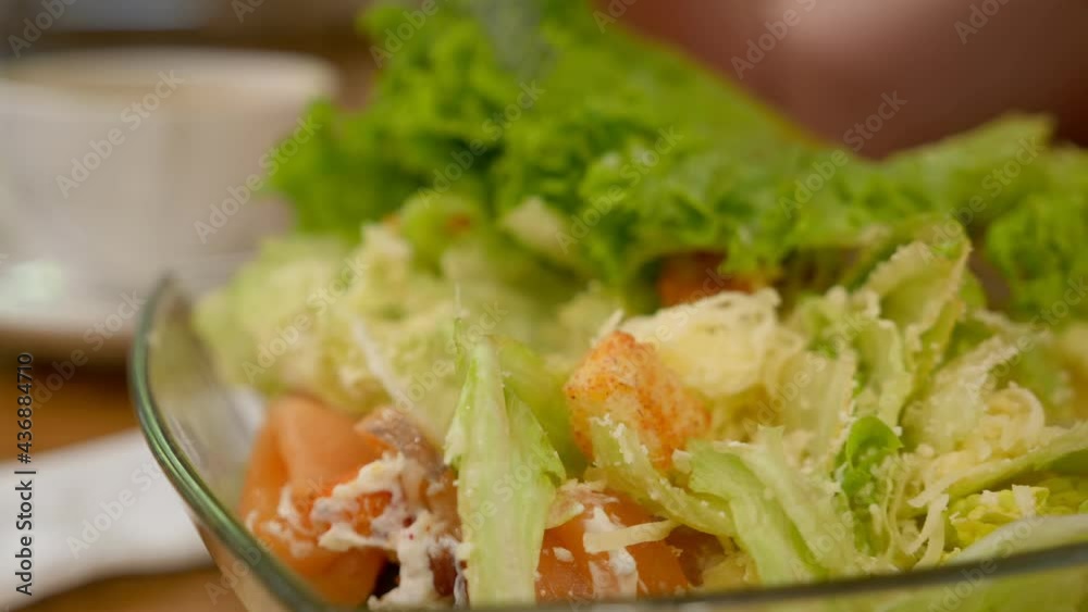 closeup woman eating caesar salad with salmon with fork closeup woman eating caesar salad with salmon with fork