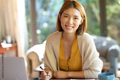 Portrait of smiling asian woman working from home