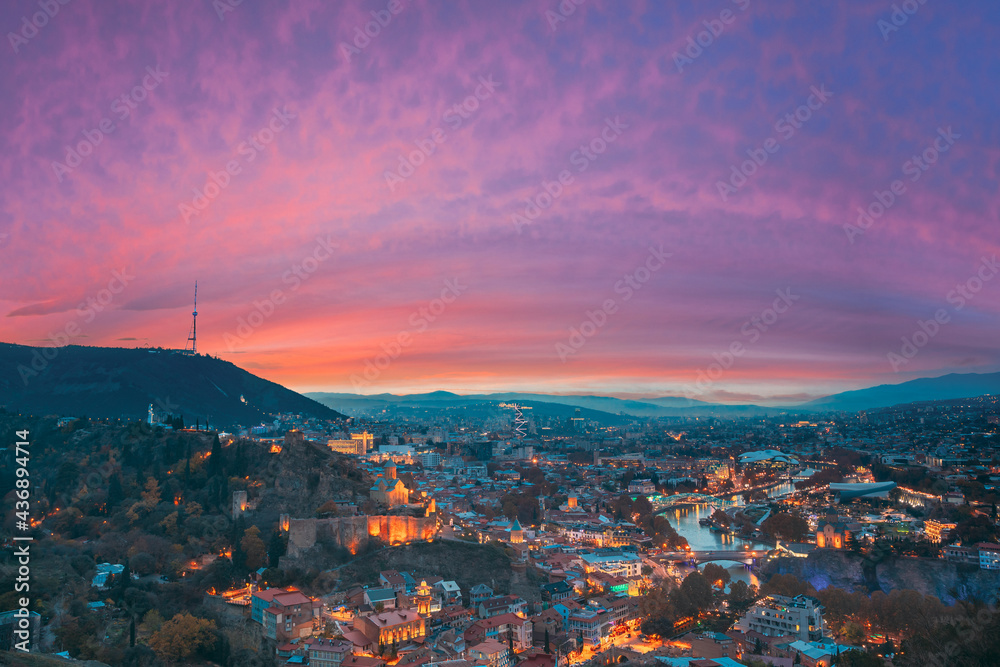 Tbilisi, Georgia. Elevated Rooftop View Of Georgian Capital City Skyline Cityscape In Evening Illuminations. Georgian Capital Skyline Cityscape. Famous Popular View. Altered Sunset Sky