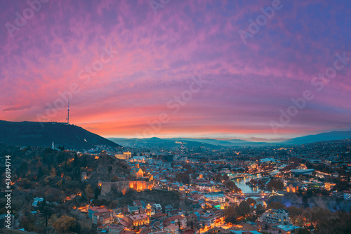 Tbilisi, Georgia. Elevated Rooftop View Of Georgian Capital City Skyline Cityscape In Evening Illuminations. Georgian Capital Skyline Cityscape. Famous Popular View. Altered Sunset Sky
