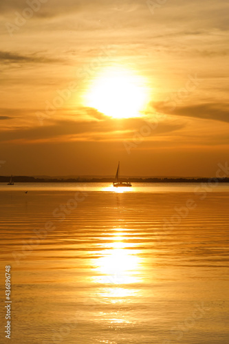 Yacht sailing against sunset. Black silhouette of sailboat. © 9parusnikov