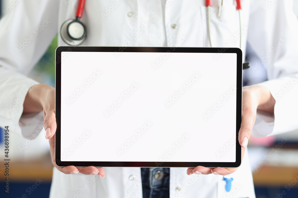 Doctor holds tablet with white screen in medical office Doctor holds tablet with white screen in medical office