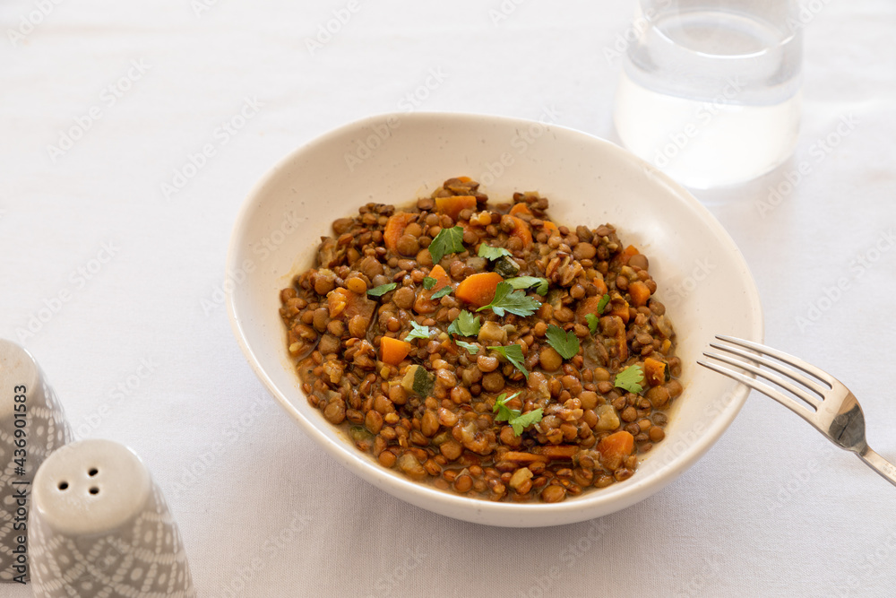 lentils with vegetables in a plate on the dining table. comfort homemade food, vegetarian lentils lentils with vegetables in a plate on the dining table. comfort homemade food, vegetarian lentils