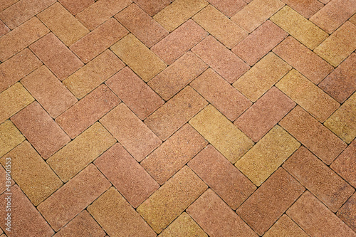 Stone block pavement. Brown and yellow paving slabs, close up. Pattern of paving blocks, top view