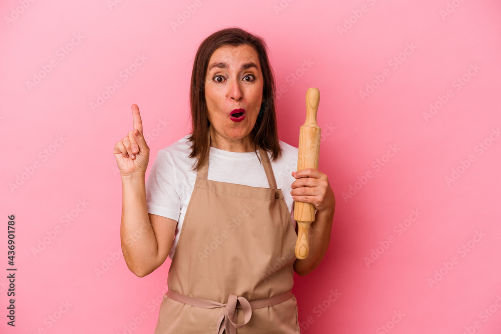 Middle age pastry chef woman isolated on pink background having some great idea, concept of creativity. Middle age pastry chef woman isolated on pink background having some great idea, concept of creativity.