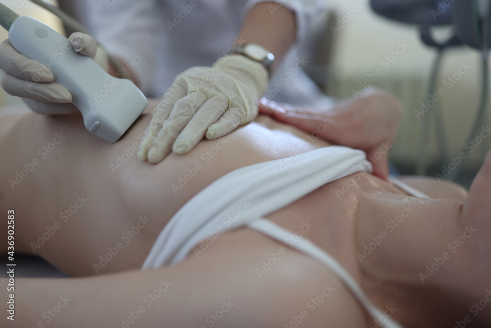 Fototapeta premium Uzist doctor conducts medical examination of mammary glands of woman
