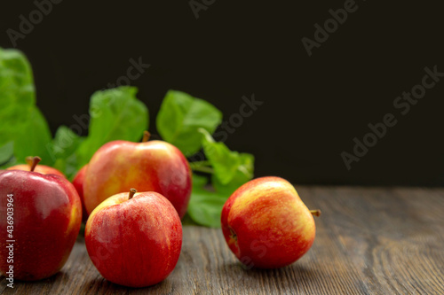 Red juicy ripe apples and green leaves