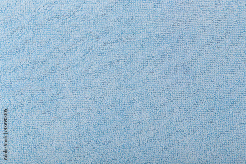 Light blue fluffy fabric background. Top view of bright blue fiber. Abstract textured background with space for text