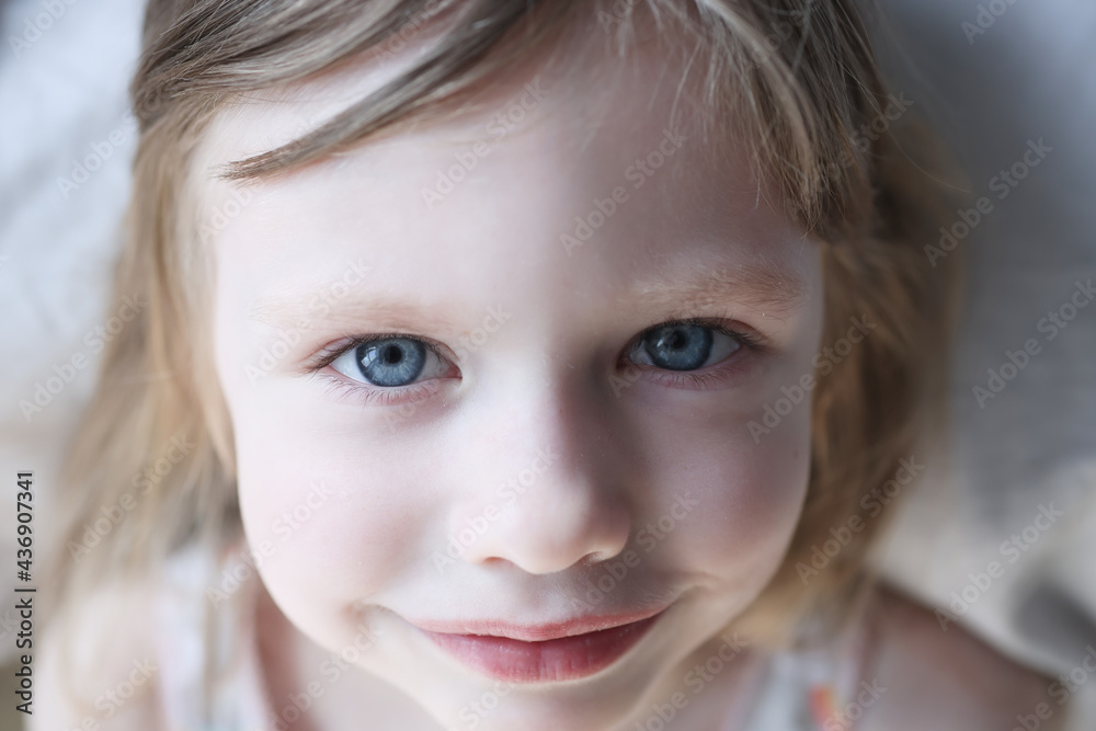 Portrait of smiling little girl with blue eyes in bed Portrait of smiling little girl with blue eyes in bed