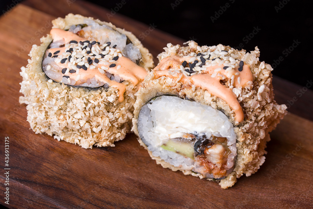 Delicious fresh rolls with red fish, awakad, cream cheese, lettuce, sesame seeds, on a wooden worthy. Delicious fresh rolls with red fish, awakad, cream cheese, lettuce, sesame seeds, on a wooden worthy.