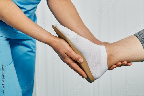 Orthopedic insoles. Orthopedist fitting individual orthopedic insole for patient foot photo