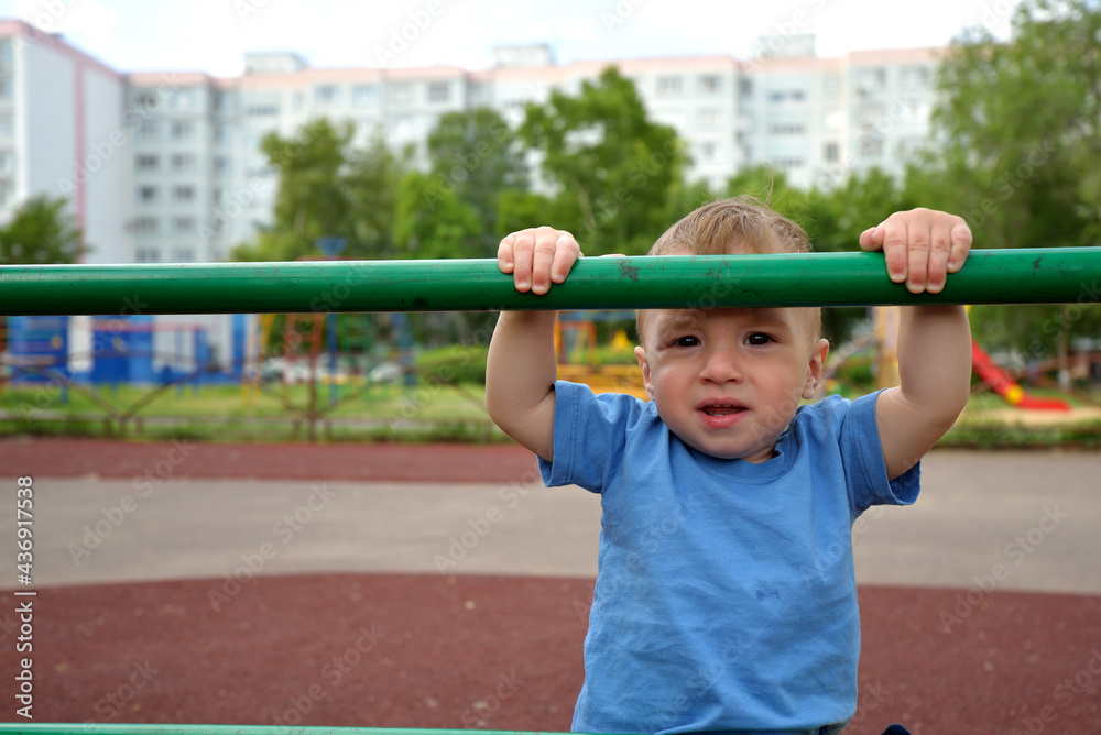 toddler boy climbs the sports ladder on the playground. sports lifestyle concept. walk in the fresh air. children play on the playground in summer. toddler boy climbs the sports ladder on the playground. sports lifestyle concept. walk in the fresh air. children play on the playground in summer.