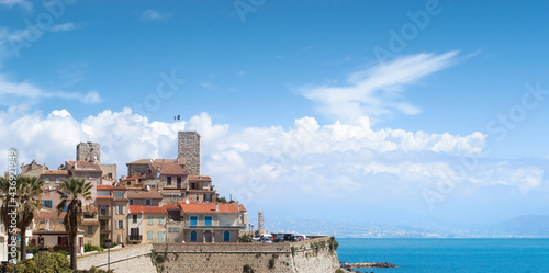 Old city of Antibes, palm trees, tower, rampart and blue mediterranean sea. © jlf46