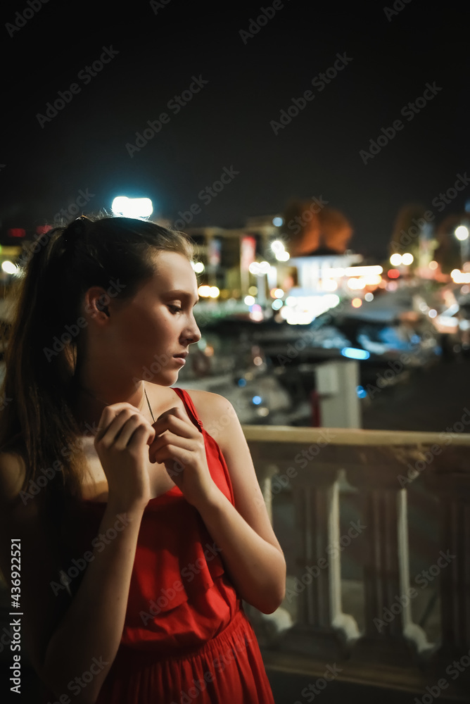 Beautiful girl posing outdoors, background with blurred neon lights Beautiful girl posing outdoors, background with blurred neon lights