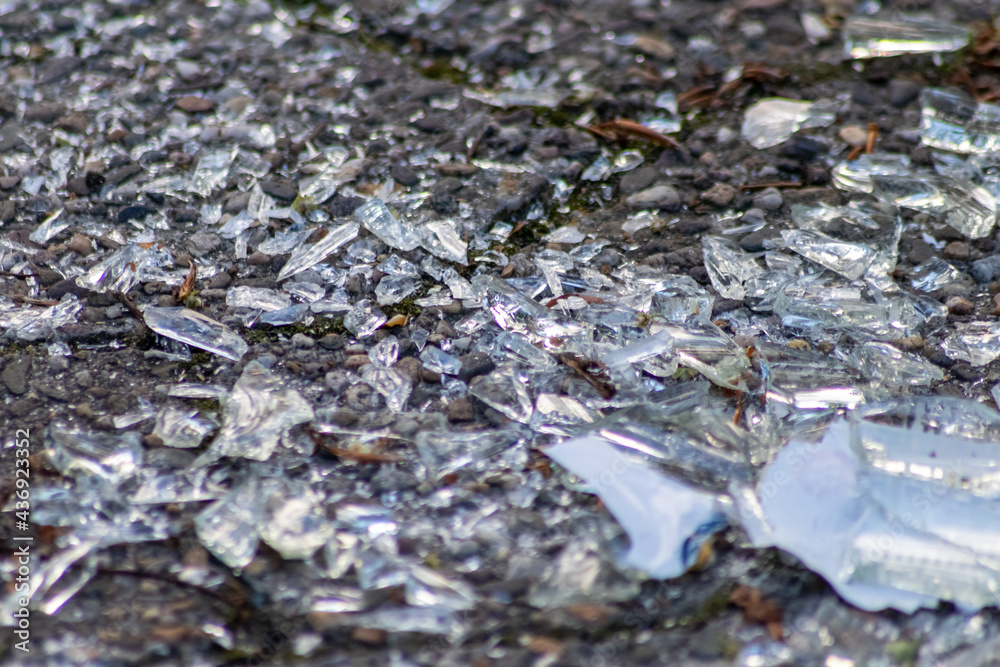 Sharp shards of a broken glass bottle on the ground with sharp blades are dangerous from