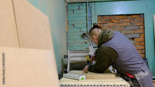 Close up. Carpenter holding a measure tape on the work bench. Woodwork and furniture making concept. Carpenter in the workshop marks out and assembles parts of the furniture cabinet photo