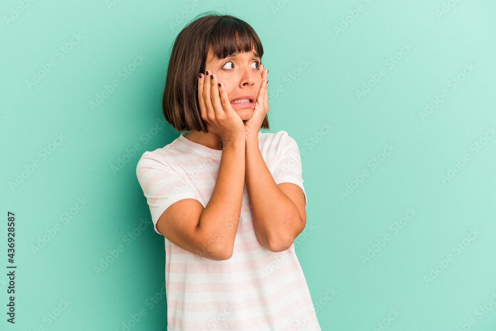 Young mixed race woman isolated on blue background stretching arms, relaxed position. Young mixed race woman isolated on blue background stretching arms, relaxed position.