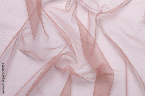 wrinkled, compressed pink tulle fabric on white background close-up photo